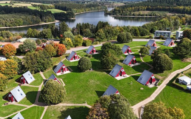 Ferienwohnungen vom Sport- und Ferienpark Worriken im Herbst. Auf dem Hintergrund ist den Bütgenbacher See zu sehen.
