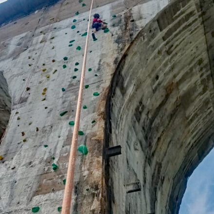 Ein Kind ist am Klettern und hat fast das höchste Punkt der Brücke erreicht.